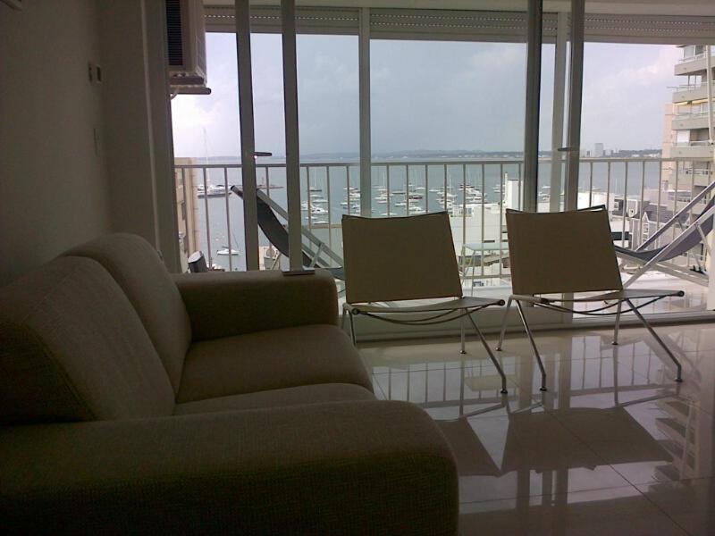 a living room with a couch and chairs and a balcony at Edificio Kennedy in Punta del Este