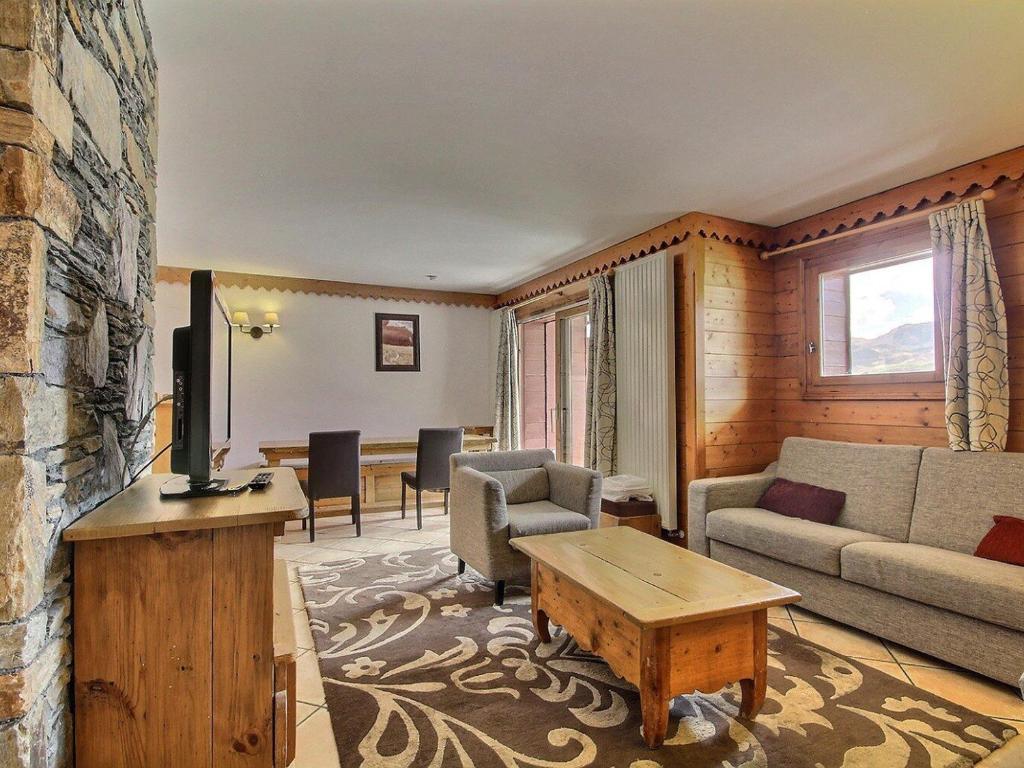 un salon avec un canapé et une télévision dans l'établissement Duplex 3 chambres avec piscine, fitness et parking couvert - FR-1-455-243, à Aime La Plagne