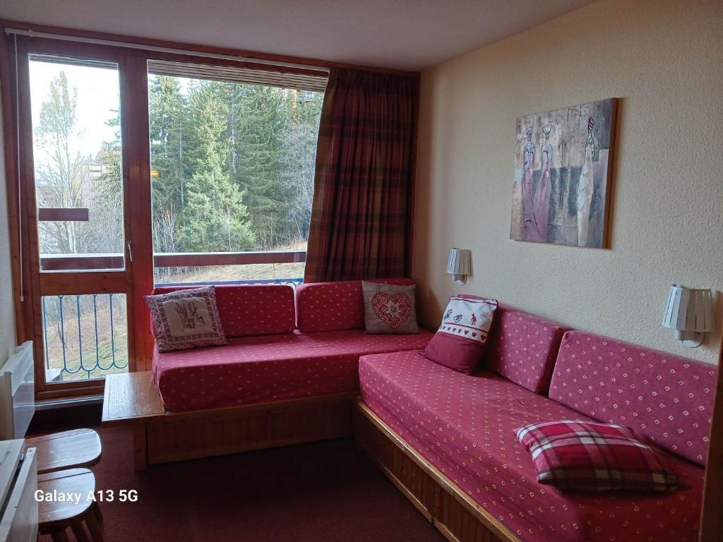 - un salon avec un canapé en face d'une fenêtre dans l'établissement Studio 2 pers au cœur des Arcs 1800, proche pistes et commerces, animaux admis - FR-1-411-921, à Bourg-Saint-Maurice