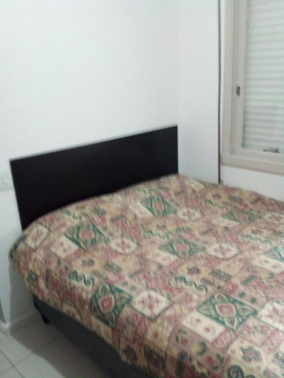 a bedroom with a bed with a quilt on it at Poa/Menino Deus in Porto Alegre