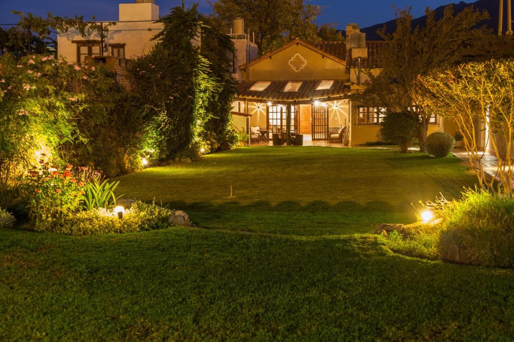 a house with lights in a yard at night at Casa del Sol Cafayate in Cafayate