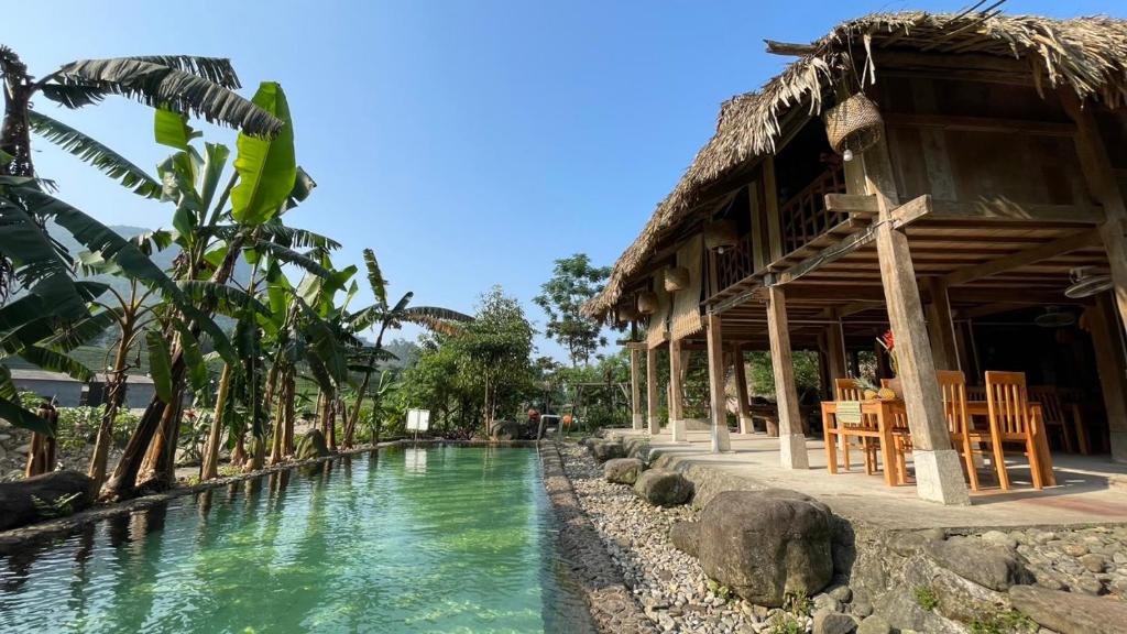 ein Resort mit einem Wasserpool neben einem Gebäude in der Unterkunft Dao's House Hoang Nong in Lá Cam