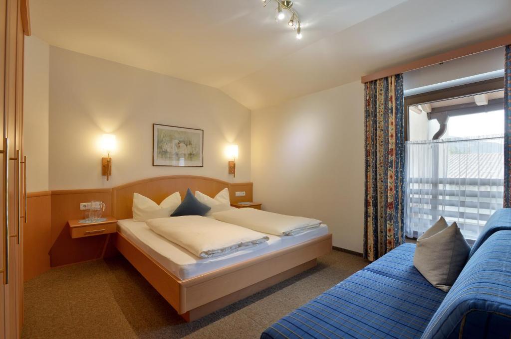 Postel nebo postele na pokoji v ubytování Hotel Garni Jennewein