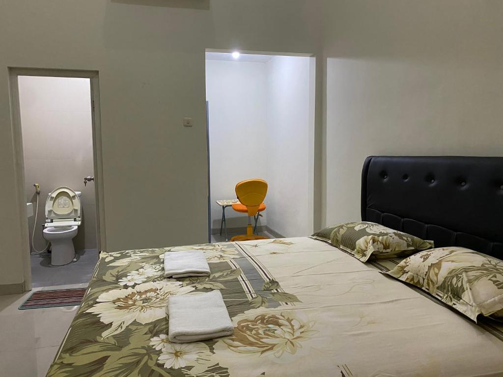 1 dormitorio con 1 cama grande y toallas. en The 8 House – Surabaya City Center, en Surabaya