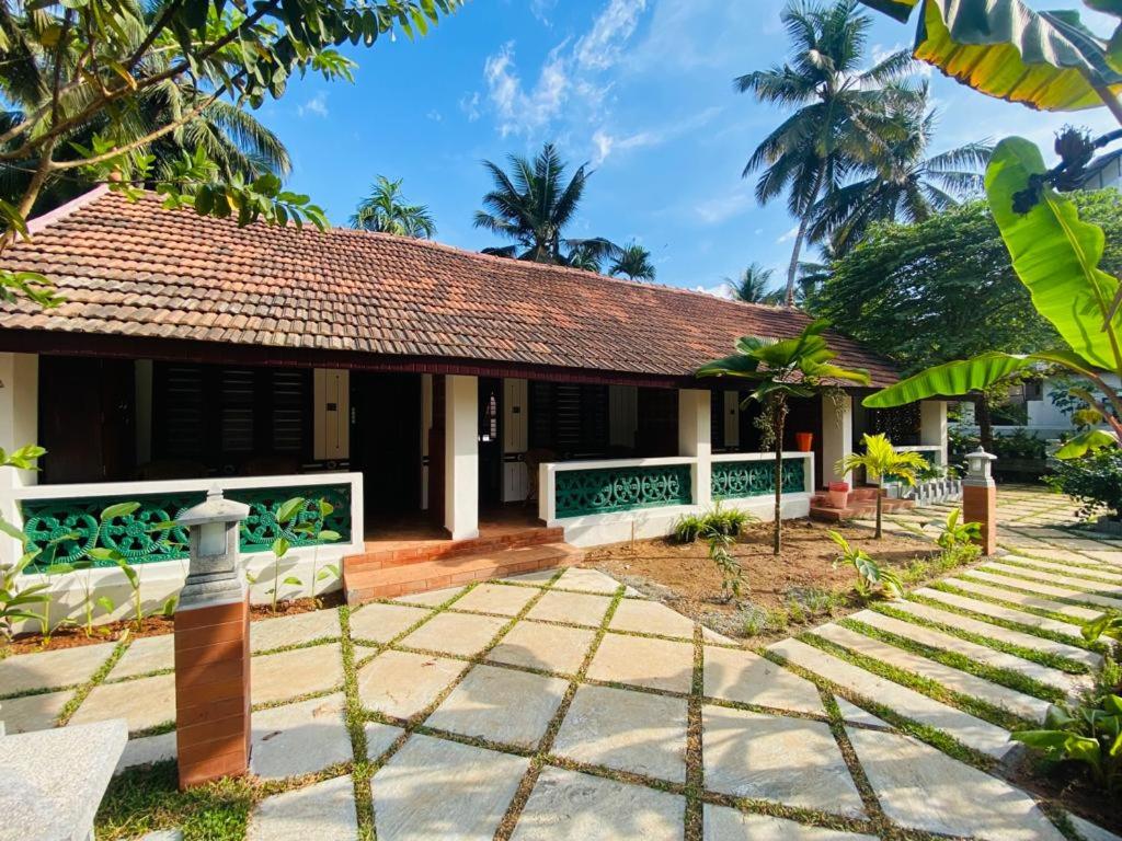 a house with a pathway leading to it at Hotel Holiday Home in Kovalam