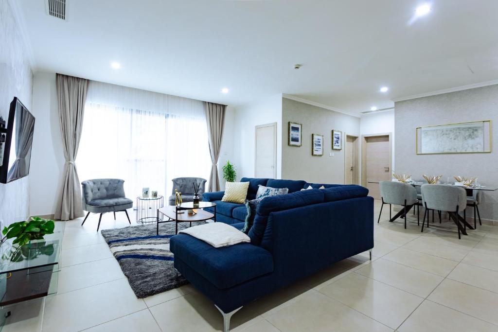 uma sala de estar com um sofá azul e uma mesa em Premium One Bedroom Seaview Space Available em Acra