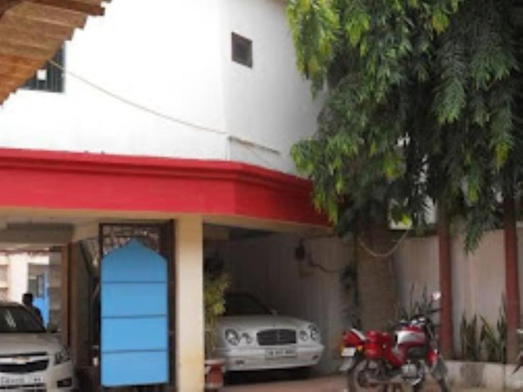 a motorcycle parked in front of a building with cars at HOTEL STEP IN Bhubaneswar in Bhubaneshwar