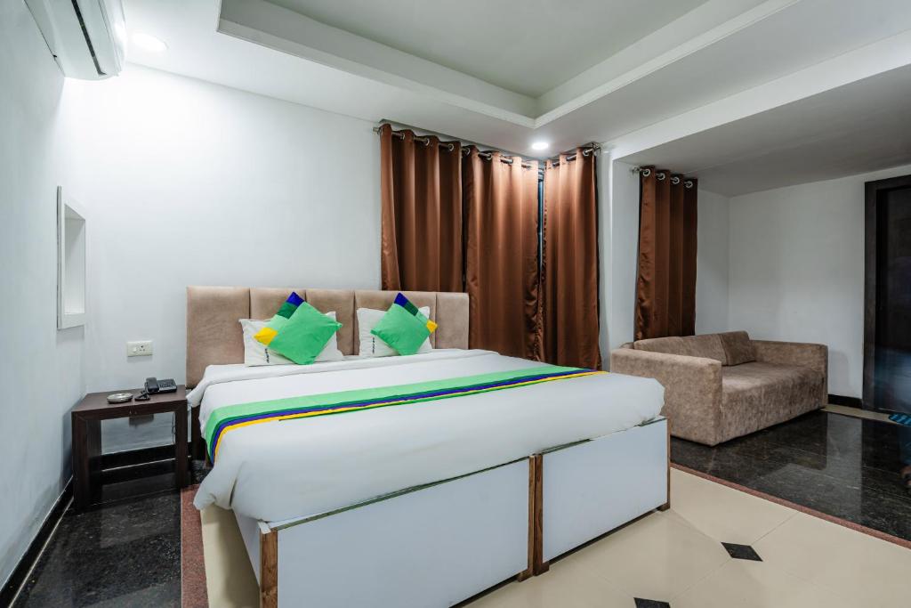 a bedroom with a large bed and a chair at Treebo Trend Silver Apartment in Dhantoli