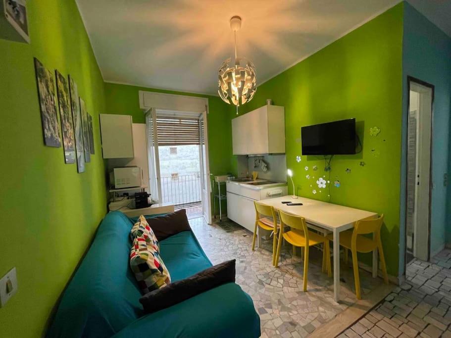 Sala de estar verde con sofá y mesa en Bilocale Lambrate/Città Studi, en Milán