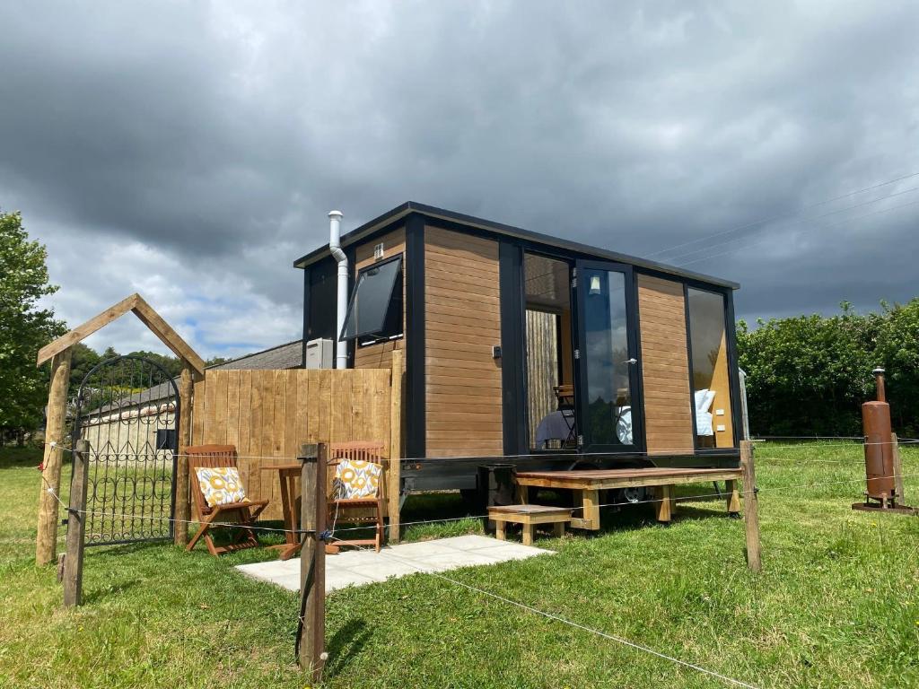 a tiny house sitting on top of a field at Forest Farm Tiny House in Tauranga