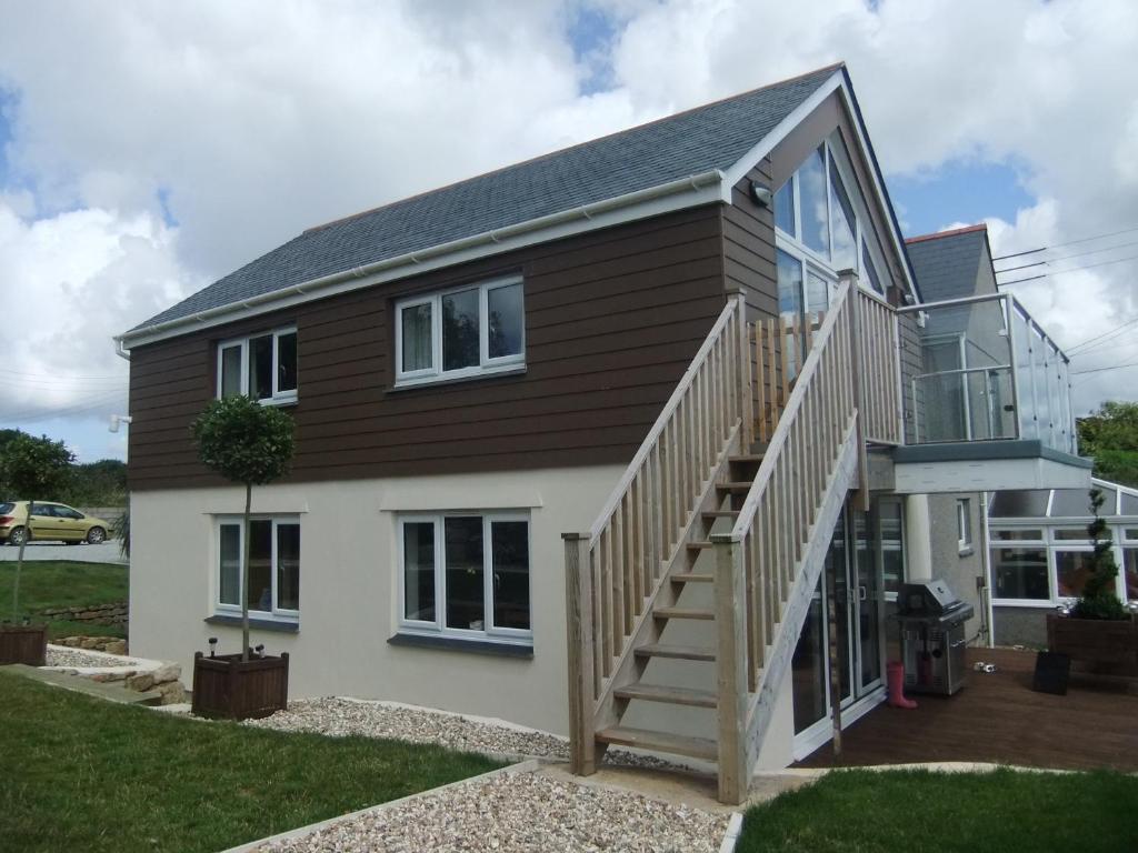 a house with a wooden staircase in front of it at The Count House in Saint Hilary