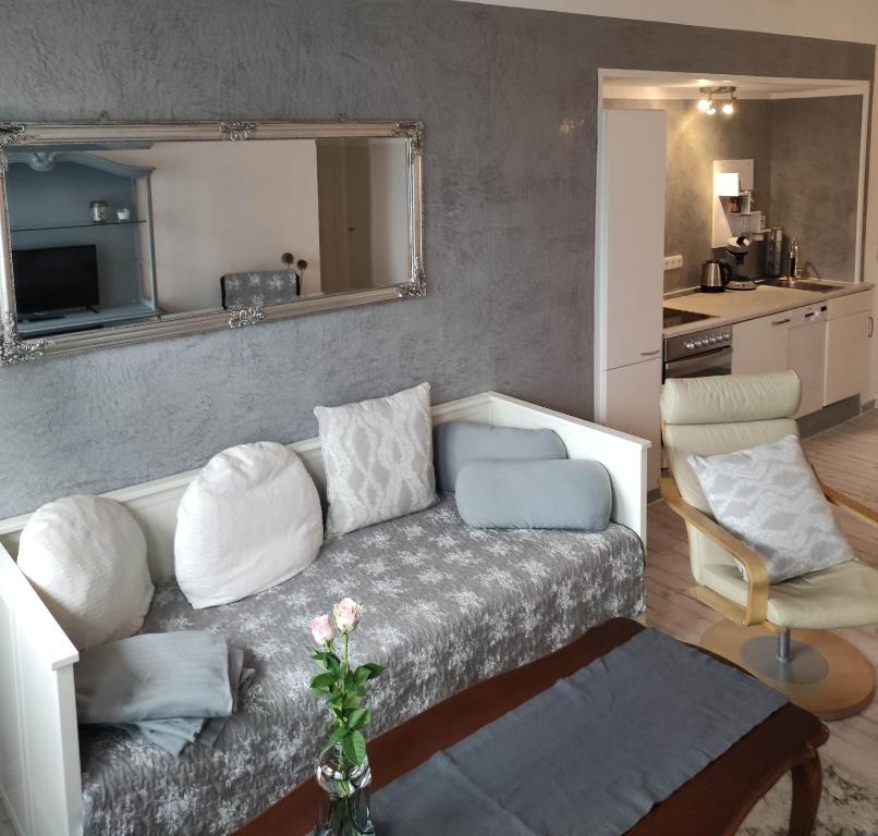 ein Wohnzimmer mit einem Sofa und einer Küche in der Unterkunft Deich in Karolinenkoog
