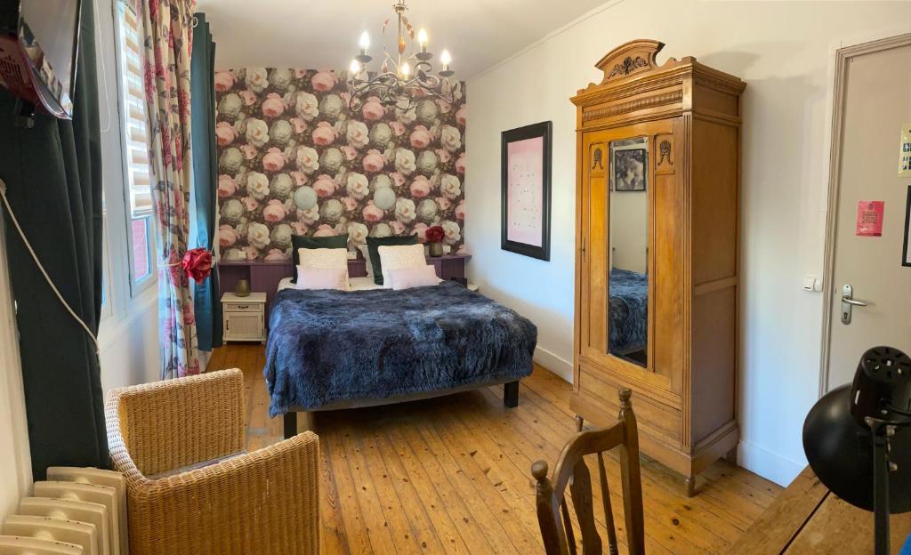 ein Schlafzimmer mit einem Bett und Stühlen in einem Zimmer in der Unterkunft LOGIS HOTEL BELLEVUE RESTAURANT LA POMME d'OR in Coucy-le-Château-Auffrique
