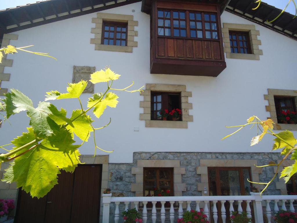 una casa bianca con finestre e foglie gialle di Montañes a Santillana del Mar