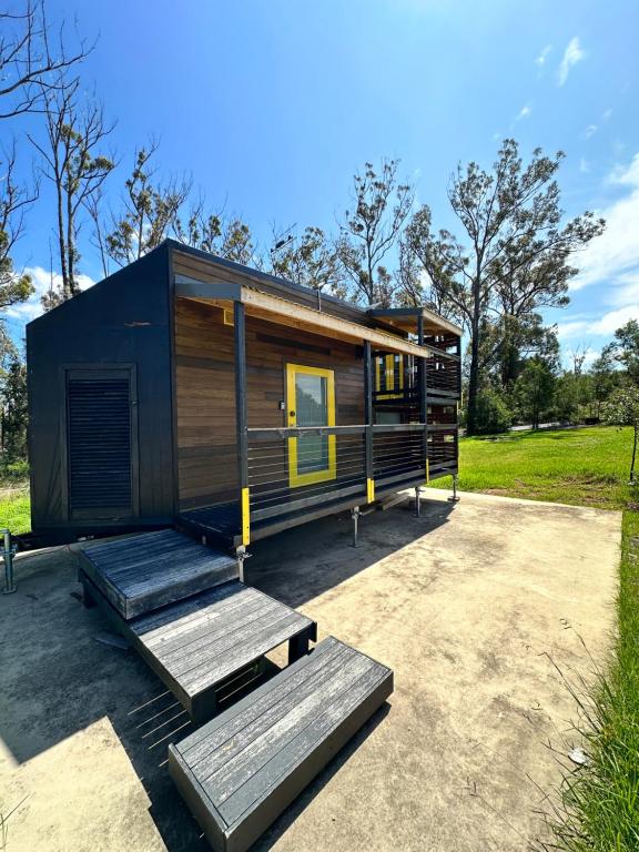 una casa pequeña sentada en la parte superior de una entrada en Ocean Breeze Tiny House - Ocean and Lake View en Mallacoota