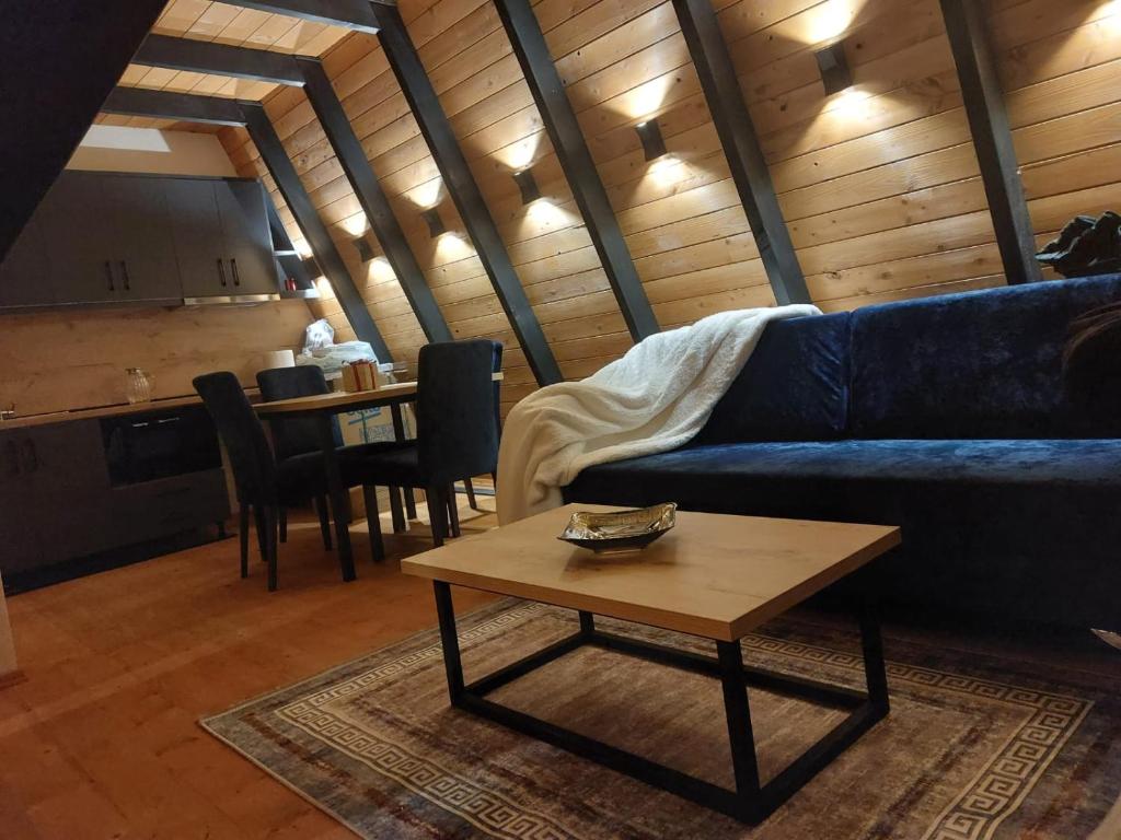 a living room with a blue couch and a coffee table at Vilat Alpine Golden Gjinar in Elbasan