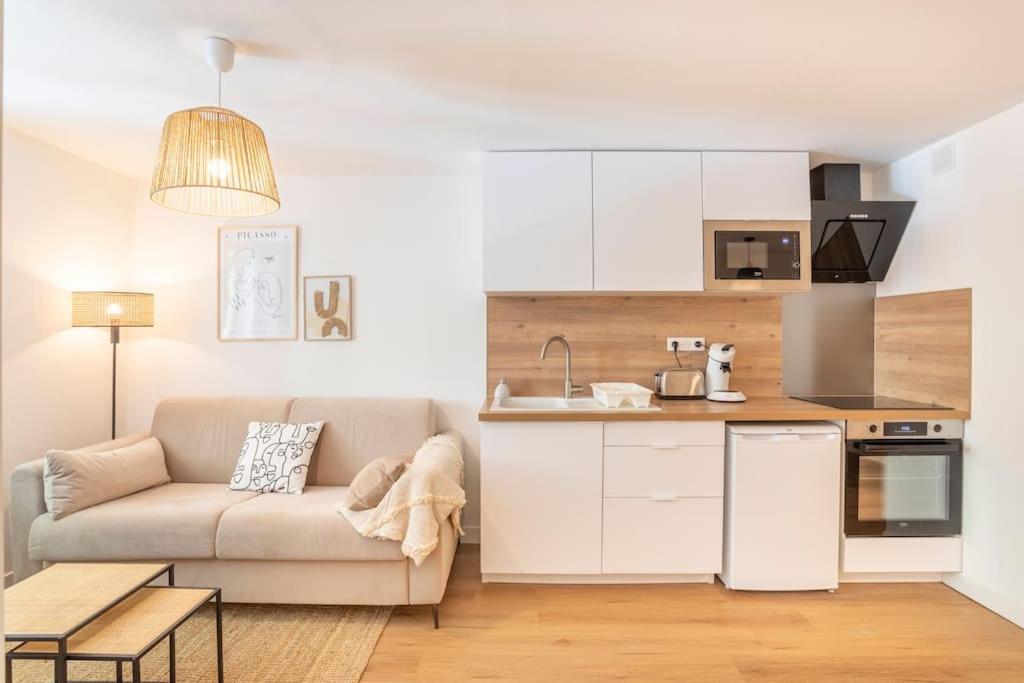 a living room with a couch and a kitchen at Le nid de la Corderie in Marseille