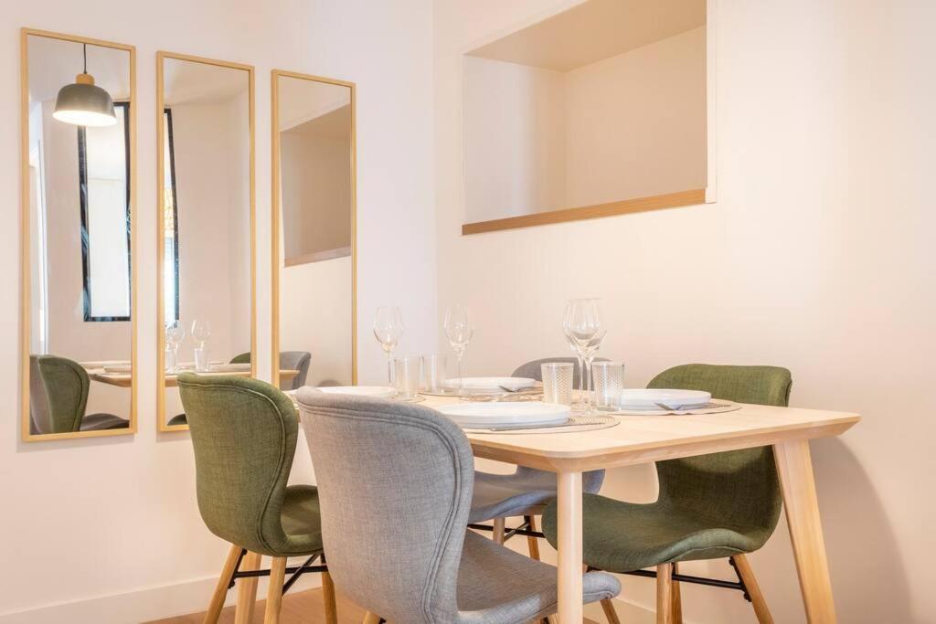 a dining room with a table with green chairs at Le nid de la Corderie in Marseille