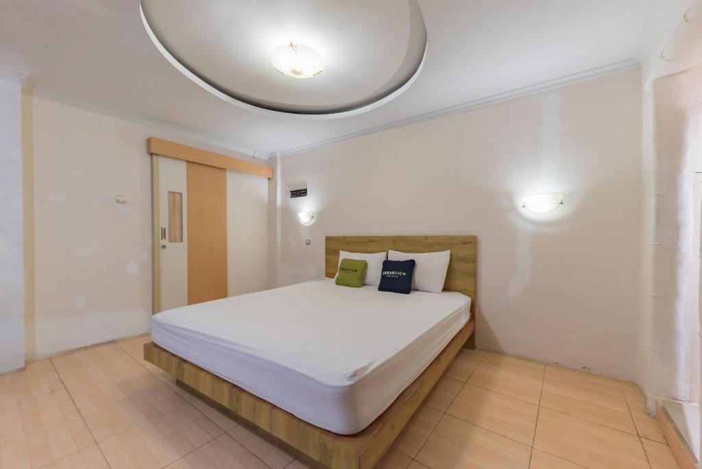 Rúm í herbergi á Urbanview Hotel Anggrek Puncak by RedDoorz