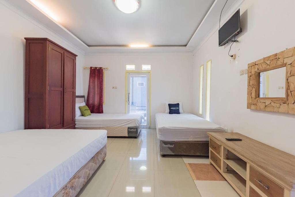 Rúm í herbergi á Urbanview Hotel Anggrek Puncak by RedDoorz
