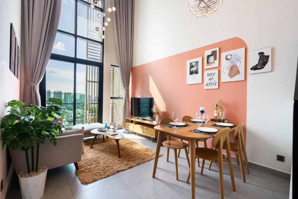 una sala da pranzo con tavolo e sedie e un soggiorno di DingD0ng Home FelizEnVista 5-star facilities ad Ho Chi Minh