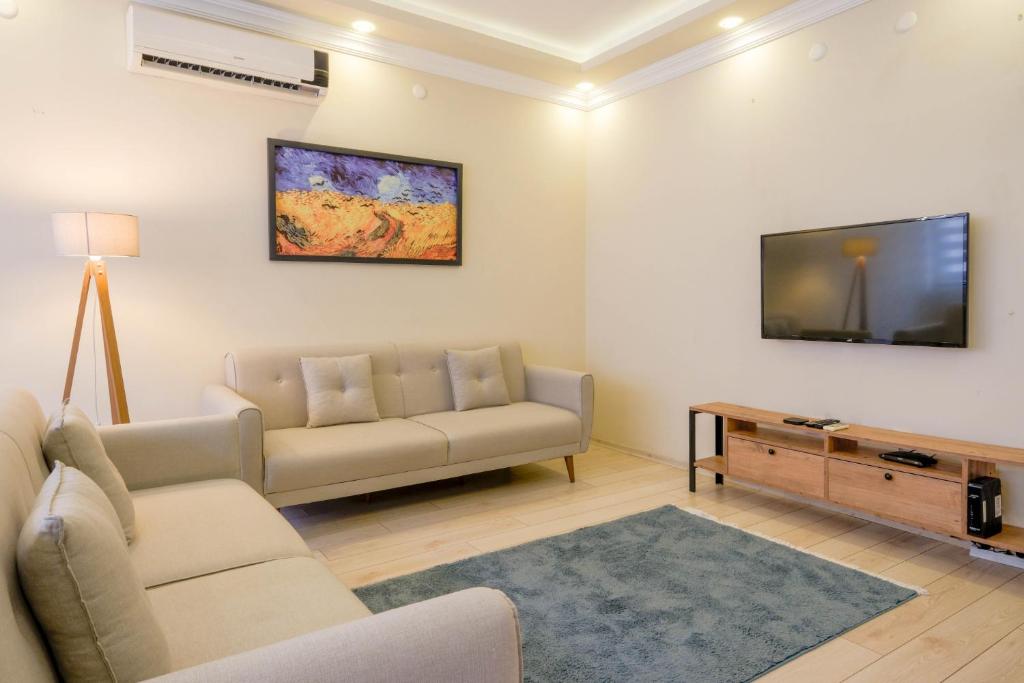 een woonkamer met een bank en een tv bij Flat w Balcony 5 min to Metro and Coast in Izmir in Izmir