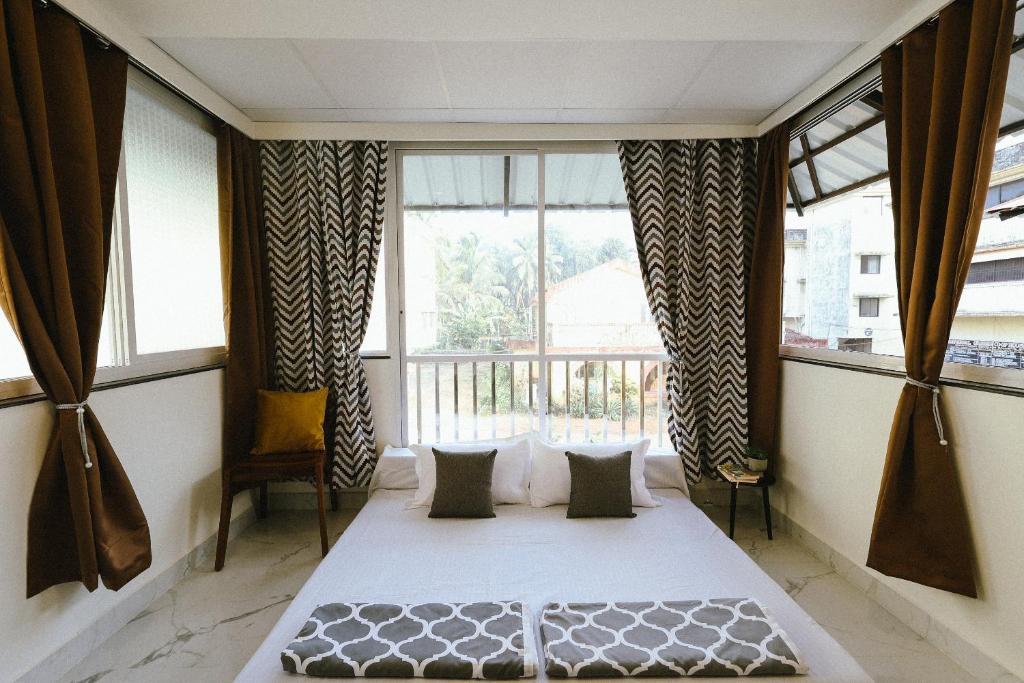 a bedroom with a bed in front of a window at Plaza de Araujo in Benaulim