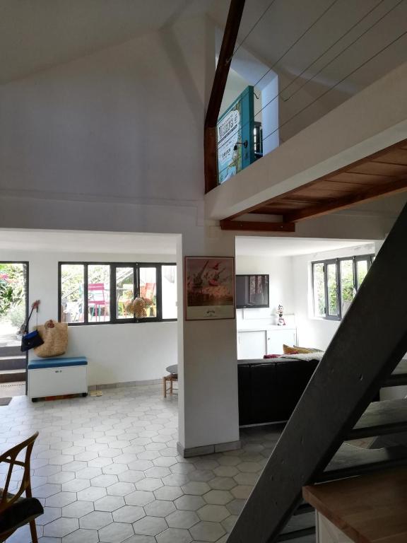 a living room with a staircase in a house at Le Séchoir-maison de vacances atypique in Petite Île