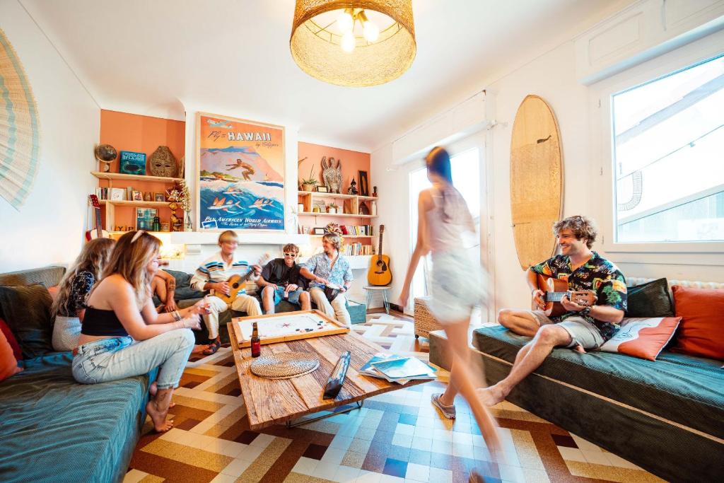 um grupo de pessoas sentadas numa sala de estar em La Boga L'Auberge à l'ambiance Surf à Biscarrosse Plage em Biscarrosse-Plage