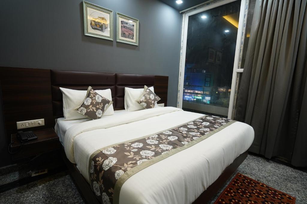 1 dormitorio con 1 cama grande y ventana en Posh Garden Inn Artemis Hospital Road Gurgaon en Gurgaon