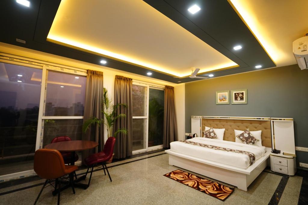 una camera con letto, tavolo e sedie di Posh Garden Inn Artemis Hospital Road Gurgaon a Gurgaon