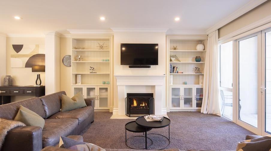 a living room with a couch and a fire place at Luxury on the Esplanade #4 in Queenstown