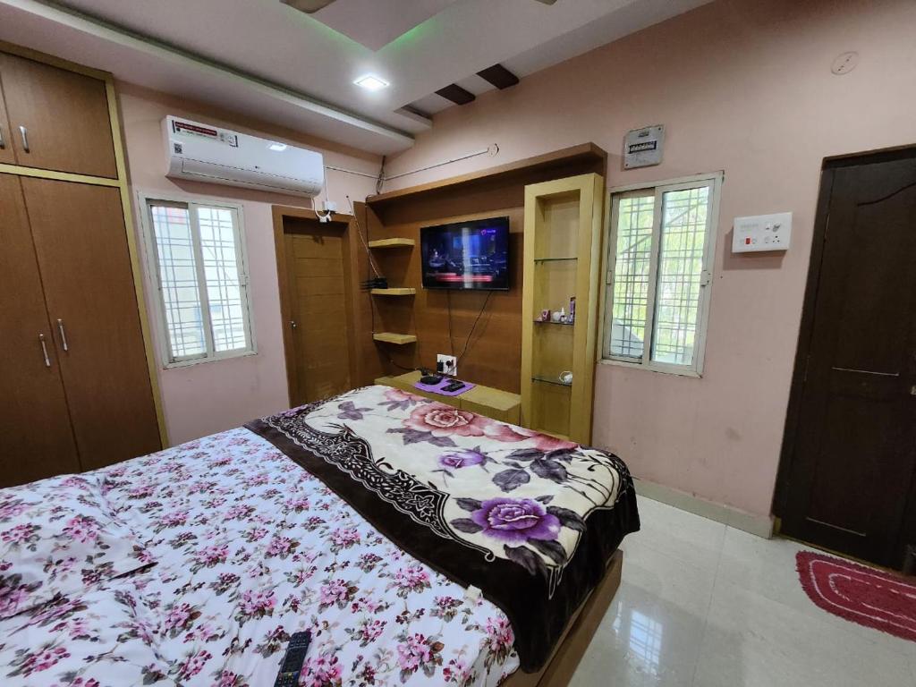 a bedroom with a bed and a tv in it at SCK Home Stay in Hyderabad
