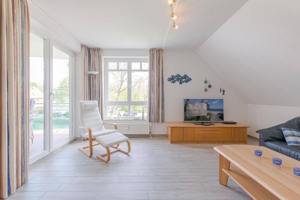 ein Wohnzimmer mit einem Sofa und einem Stuhl in der Unterkunft Appartementanlage Likedeeler, Ferienwohnung 41 in Boltenhagen