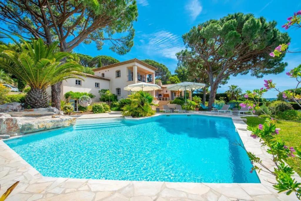 une piscine devant une maison avec des arbres dans l'établissement Superbe villa avec piscine et vue mer - Villa Capella, à La Croix-Valmer