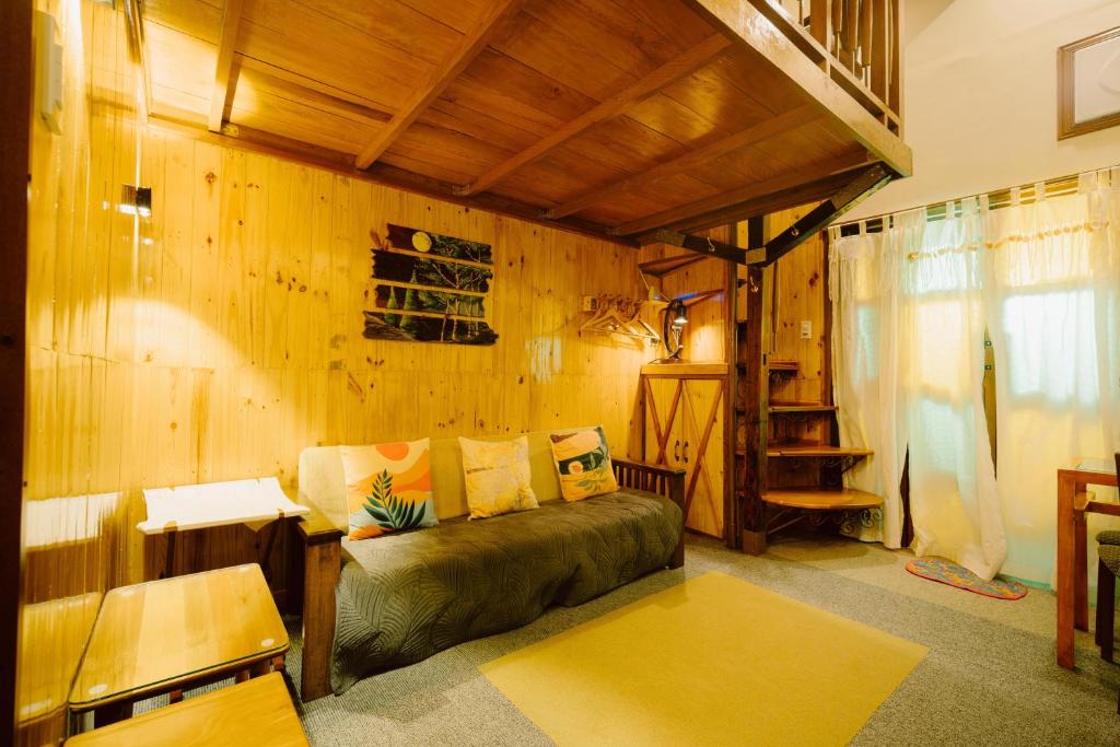 a living room with a couch and a wooden wall at Antonio's Bed and Breakfast Hotel in Balogo