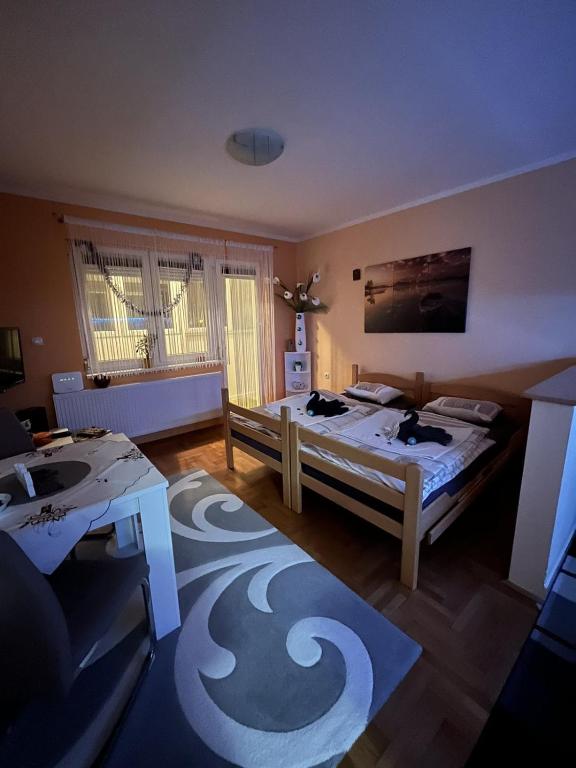 ein Wohnzimmer mit 2 Betten und einem Tisch in der Unterkunft Apartman B&S Apatin in Apatin