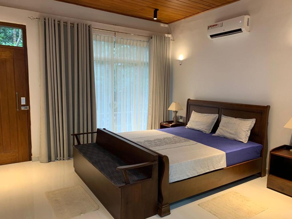a bedroom with a bed and a window at Rani Suite and Cabin in Kandy