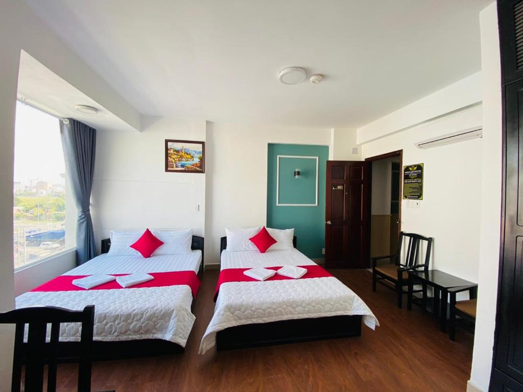 een hotelkamer met 2 bedden en een bureau bij Phú Gia 113 NTT in Ho Chi Minh-stad