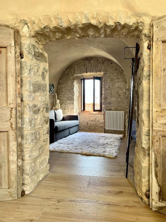 a living room with a couch and a stone wall at La Finestra di Dante in Mulazzo