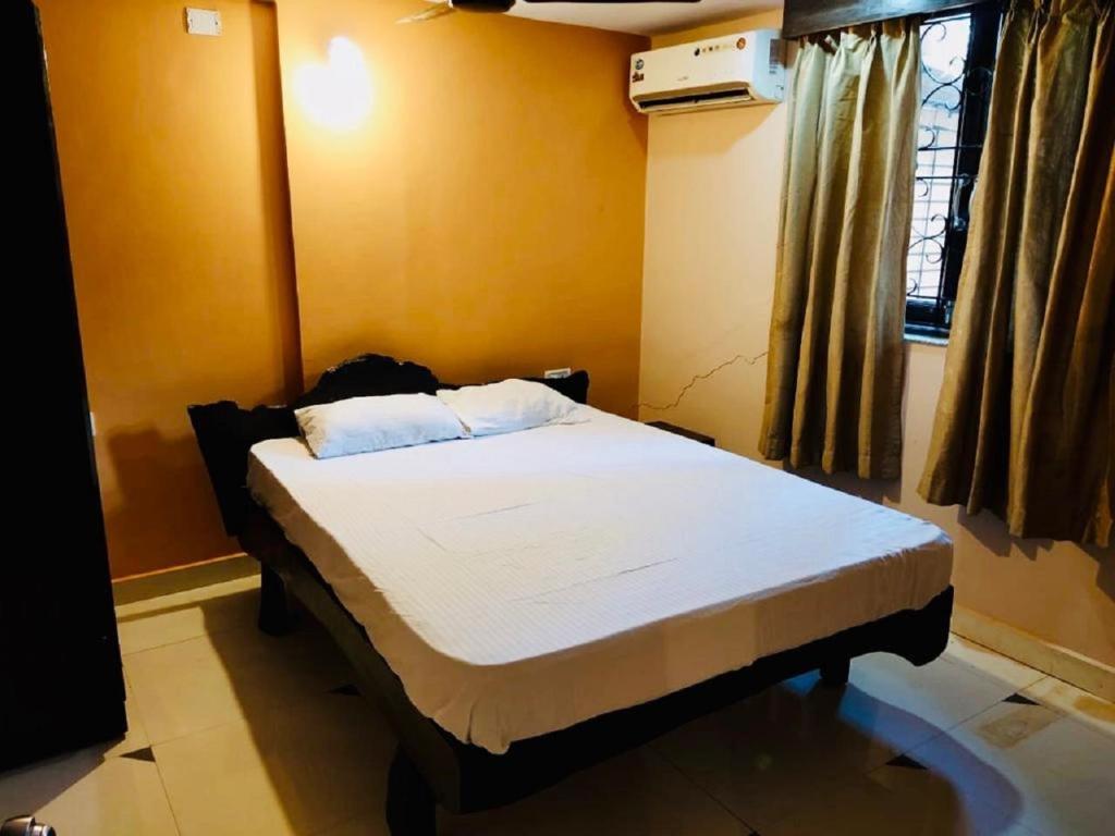 - une chambre avec un lit dans une pièce dotée d'une fenêtre dans l'établissement 2BHK Affordable Apartment in North Goa - Baga and Anjuna Beach Nearby, Parra Road, à Goa