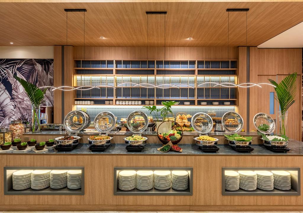 a buffet with plates of food on a counter at Oakwood Hotel & Apartments Taman Mini Jakarta in Jakarta