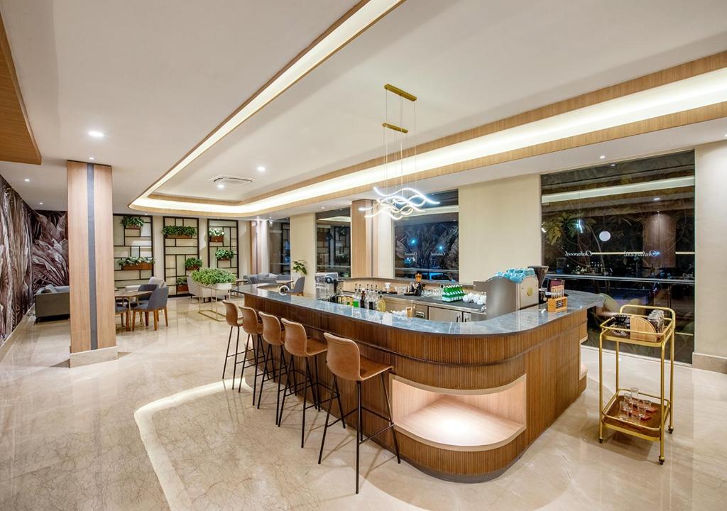 a lobby with a bar with stools at Oakwood Hotel & Apartments Taman Mini Jakarta in Jakarta