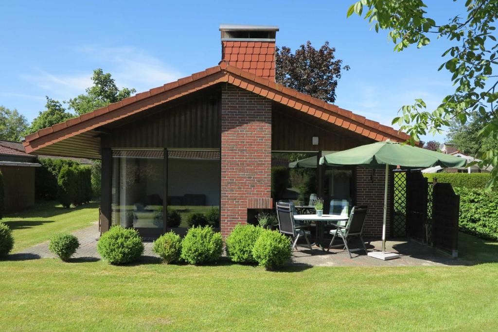 a brick house with a table and an umbrella at Ferienlandhaus Schäfer in Tossenserdeich