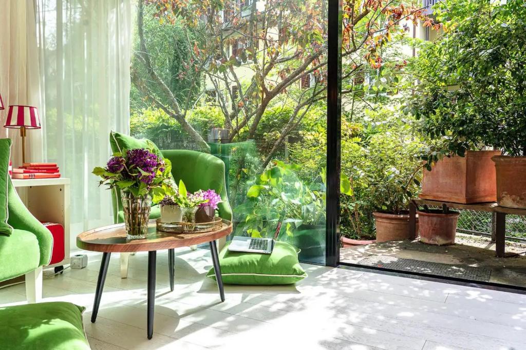 a living room with a table and green chairs at Stylish Garden-Gem by Lake: Pet-Friendly & Central in Zürich