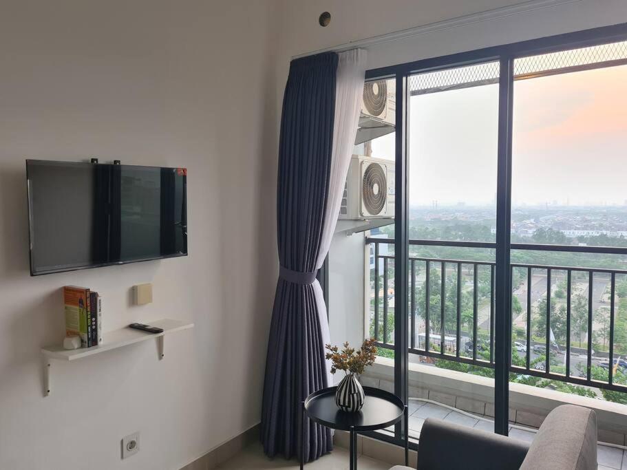 a living room with a large window with a view at Urban Oasis Bekasi in Tambun-lobangbuaja