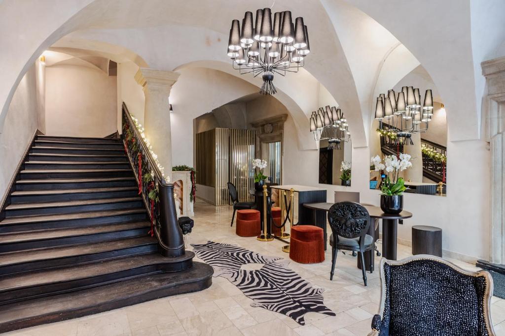 a lobby with a staircase and a chandelier at Hotel Unicus Palace Old Town in Kraków