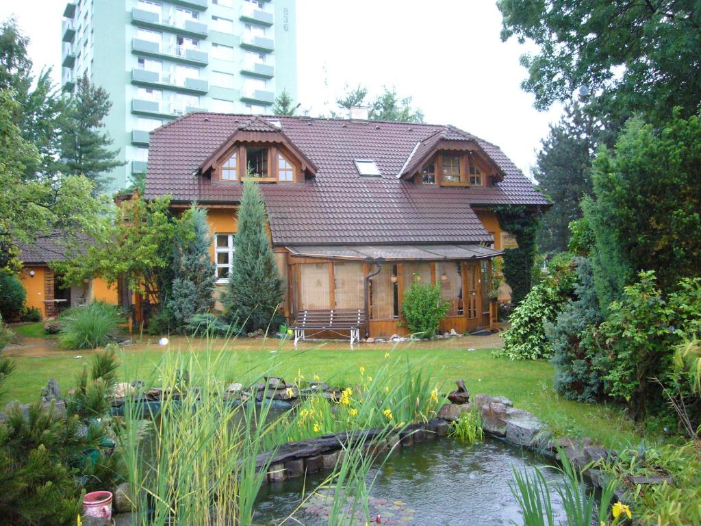 ein Haus mit einem Teich davor in der Unterkunft Penzion U Vejvodu in Třeboň