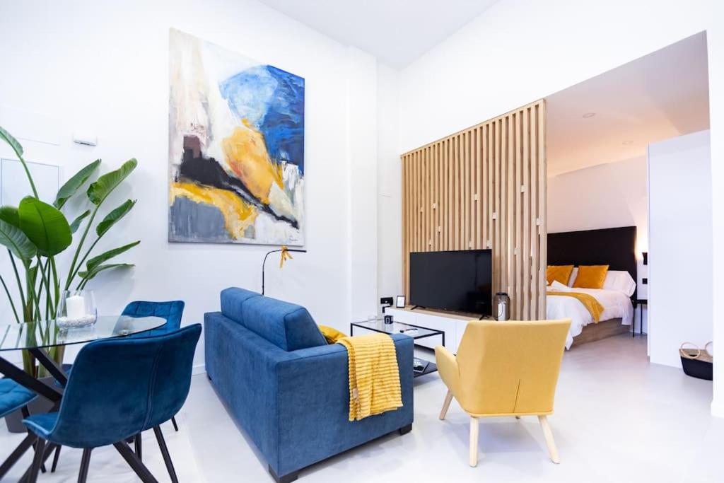 a living room with a blue couch and chairs and a bed at Loft 11 B in Murcia