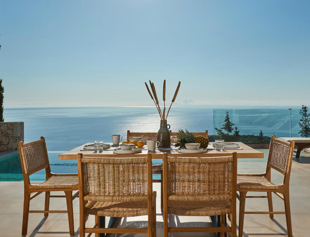 a dining table and chairs with a view of the ocean at Thelxi's Suite II - Brand New Seaview Suite! in Volimes